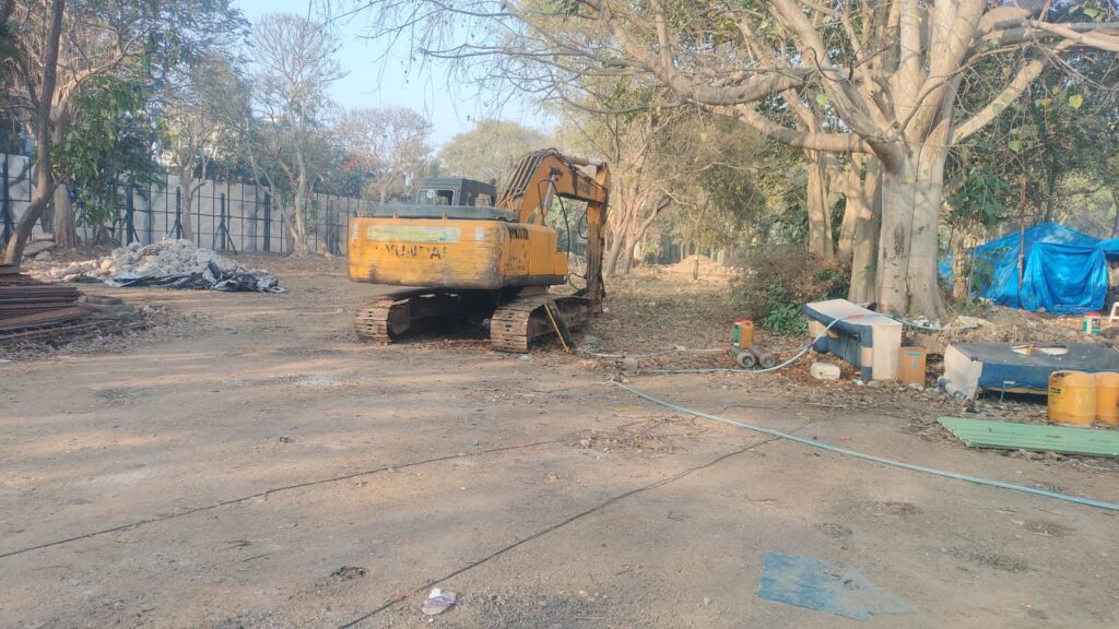 Hydraulic excavator performing professional building demolition services in Bangalore